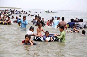 Large number of people enjoy bathing to get relief from scorching hot weather at Keenjhar Lake.