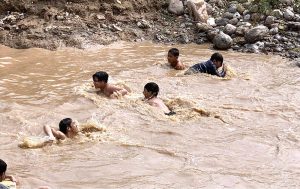 A group of youngsters bathing in water pond to get some relief from scorching hot weather in Federal Capital.