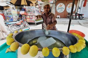 A vendor preparing traditional summer drink (Shikanjabeen) for the customers at Ghanta Ghar Chowk.