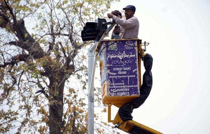 TMA workers are busy repairing the traffic signal at the University Chowk