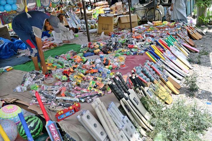 A young vendor displays sports items at his roadside setup to attract passersby in the federal capital