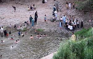 Youngsters enjoy bathing in Korang Nallah near Chak Shahzad to seek relief from the extreme heatwave gripping the Federal Capital.