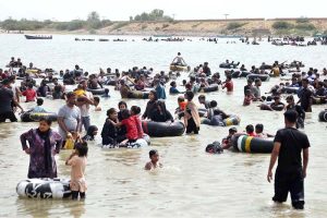 Large number of people enjoy bathing to get relief from scorching hot weather at Keenjhar Lake.