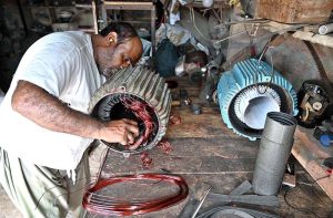 A mechanic is repairing an electric motor at his workplace.