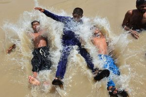 Youngsters beat the scorching heat by diving into a canal, turning the sweltering weather into a moment of joy and relief