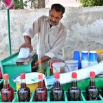 A vendor sells Ice Gola at his roadside stall on Tariqabad Road to offer relief from the extreme heatwave gripping the city