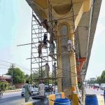 PHA workers give a fresh coat of paint and clean up the Metrobus track amid beautification drive of the twin cities