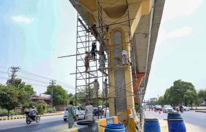 PHA workers give a fresh coat of paint and clean up the Metrobus track amid beautification drive of the twin cities