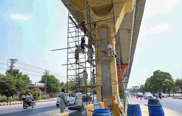 PHA workers give a fresh coat of paint and clean up the Metrobus track amid beautification drive of the twin cities