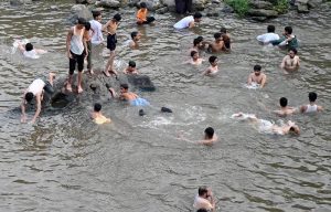 Youngsters enjoy bathing in Korang Nallah near Chak Shahzad to seek relief from the extreme heatwave gripping the Federal Capital.