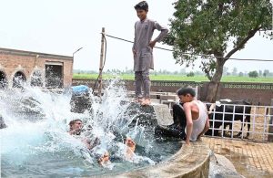 Youngsters are taking bath in a tube well in a village to get some relief from scorching hot weather in the city
