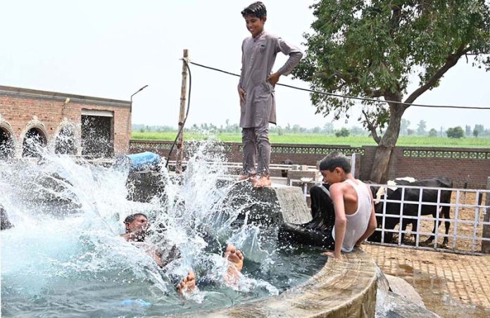 Youngsters are taking bath in a tube well in a village to get some relief from scorching hot weather in the city