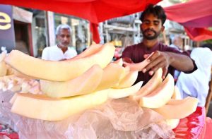 A vendor displaying fruit on his hand cart setup to attract the customers.