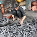 A vendor displaying coal to attract the customers at his shop in a local market
