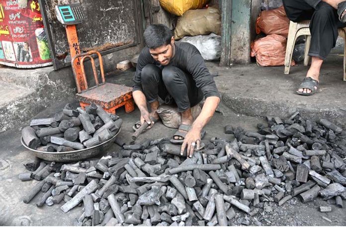 A vendor displaying coal to attract the customers at his shop in a local market