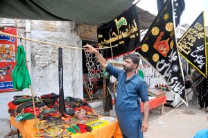 A vendor displaying Muharram procession related stuffs to attract people.