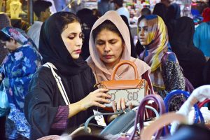 Women busy in selecting and purchasing hand bags from stall for preparation of upcoming Eid-ul-Adha in a local market