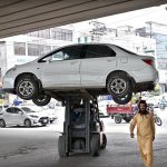 Traffic police official removing wrongly parked vehicle on Murree Road with the help of lifter