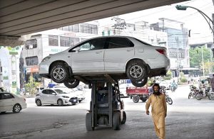 Traffic police official removing wrongly parked vehicle on Murree Road with the help of lifter