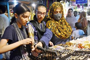 Women busy in selecting and purchasing hand bags from stall for preparation of upcoming Eid-ul-Adha in a local market