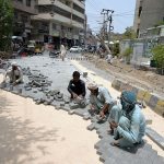 Labourers engaged in groundwork for the installation of cement tiles as part of road construction near Press Club Road.