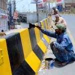 PHA staffers are busy paint the boundary wall of bridge during beautification work in the city.