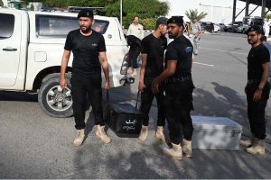 Police commandos from Pakistan’s Federal Board of Revenue (FBR) shift boxes with copies of the 2025–26 fiscal budget outside the Parliament House, before the start of the budget session