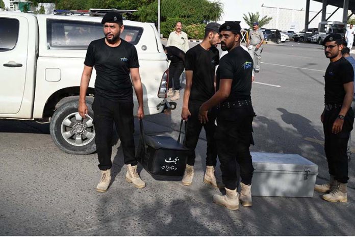 Police commandos from Pakistan’s Federal Board of Revenue (FBR) shift boxes with copies of the 2025–26 fiscal budget outside the Parliament House, before the start of the budget session
