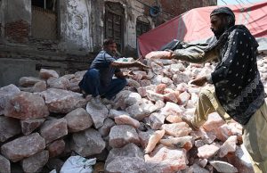 Workers select and sort pink salt at his workplace to ensure high quality for export