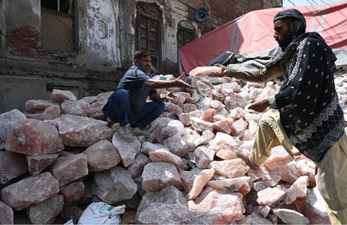 Workers select and sort pink salt at his workplace to ensure high quality for export