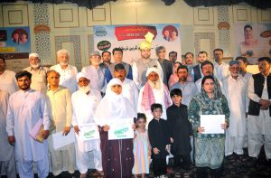 Provincial Minister for Agriculture and Livestock Syed Ashiq Kirmani in a group photo with farmers after handing over green tractor documents to farmers during a ceremony under CM Punjab’s Agricultural Support Initiative at a local hall.