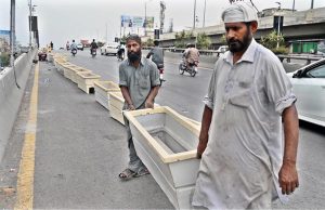 RDA workers install plant pots along a roadside bridge as part of a beautification and greening drive in the twin cities
