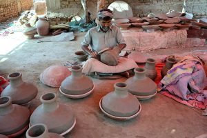 A worker preparing clay-made pitcher at his work place Kumharpara near Jamshoro road.