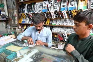Artisan making number plate at his shop.