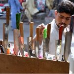 A person selecting knives to be used for slaughtering sacrificial animals during Eid-ul-Azha