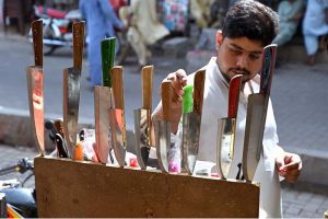 A person selecting knives to be used for slaughtering sacrificial animals during Eid-ul-Azha