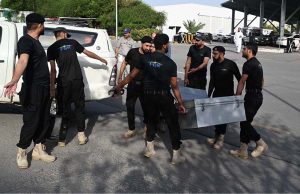 Police commandos from Pakistan’s Federal Board of Revenue (FBR) shift boxes with copies of the 2025–26 fiscal budget outside the Parliament House, before the start of the budget session