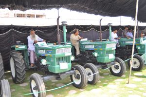 Provincial Minister for Agriculture and Livestock Syed Ashiq Kirmani in a group photo with farmers after handing over green tractor documents to farmers during a ceremony under CM Punjab’s Agricultural Support Initiative at a local hall.