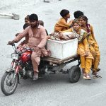 A nomad family travels on a motorcycle cart, relocating in search of relief from the ongoing heatwave as temperatures soar in the city