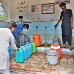 Residents queue up at a filtration plant with only two working taps amid the scorching heat in Pathan Colony