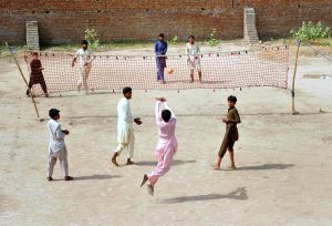 Children play volleyball to spend their leisure time in an open field on the outskirts of the city.
