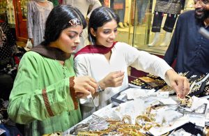 Girls busy in selecting and purchasing artificial jewelry from stall for preparation of upcoming Eid-ul-Azha in a local market
