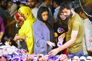 Girls busy in selecting and purchasing artificial jewelry from stall for preparation of upcoming Eid-ul-Azha in a local market