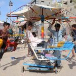 Children enjoy swing ride on the third day of Eid ul Azha at Chanesar Goth