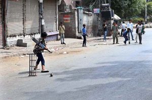 Boys playing cricket on the Mcleod Road.