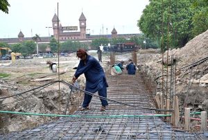 Workers are busy in construction work nullah in front of the Railway Station.