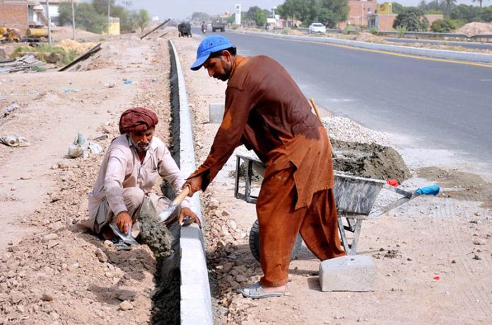 Labourers are busy fixing cemented blocks along head Muhammad Wala Road