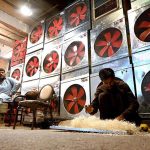 A worker preparing “Khas” used in local made air-coolers at his roadside workplace