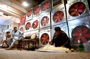 A worker preparing “Khas” used in local made air-coolers at his roadside workplace