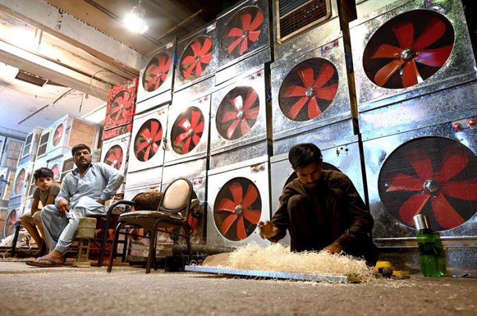 A worker preparing “Khas” used in local made air-coolers at his roadside workplace